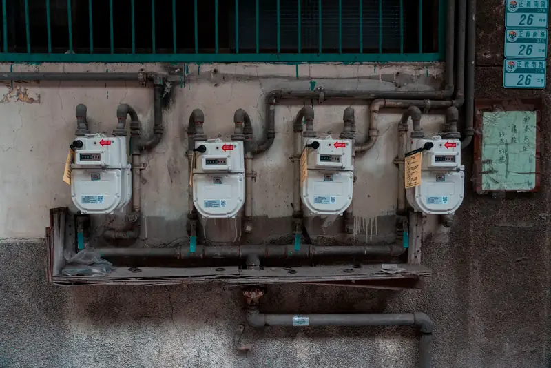 Four gas meters mounted on an exterior wall, showcasing urban utility infrastructure.