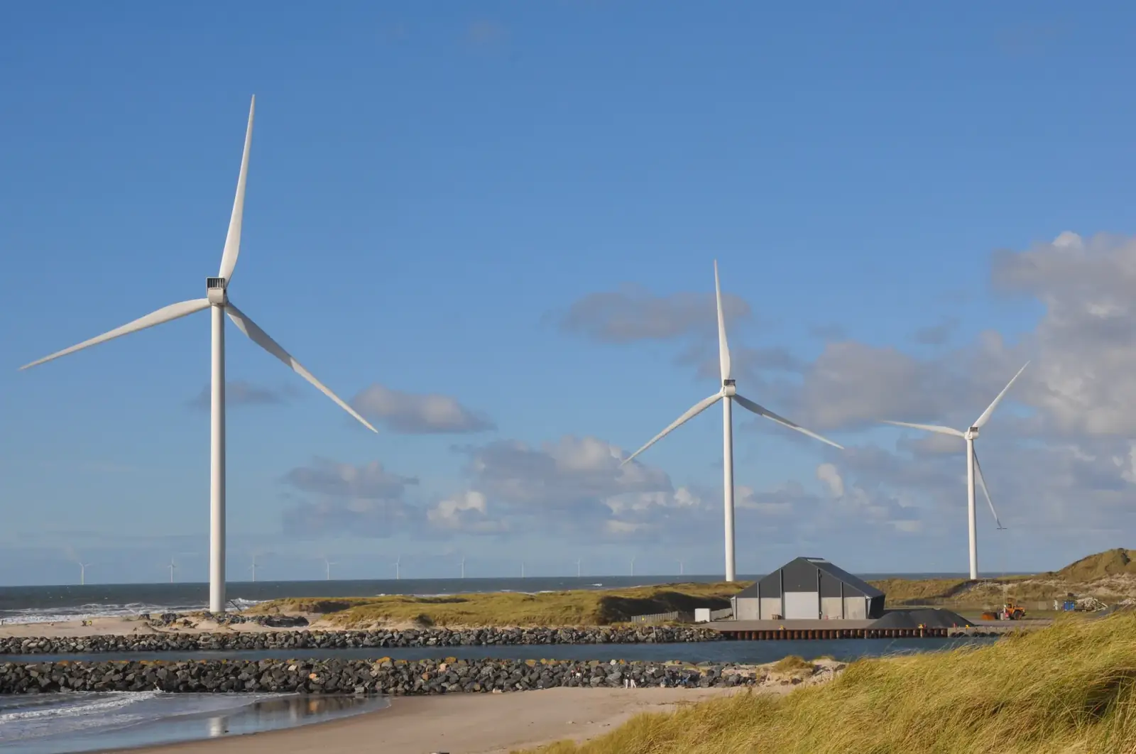 Scenic view of wind turbines along the coast of Hvide Sande, Denmark on a sunny day.