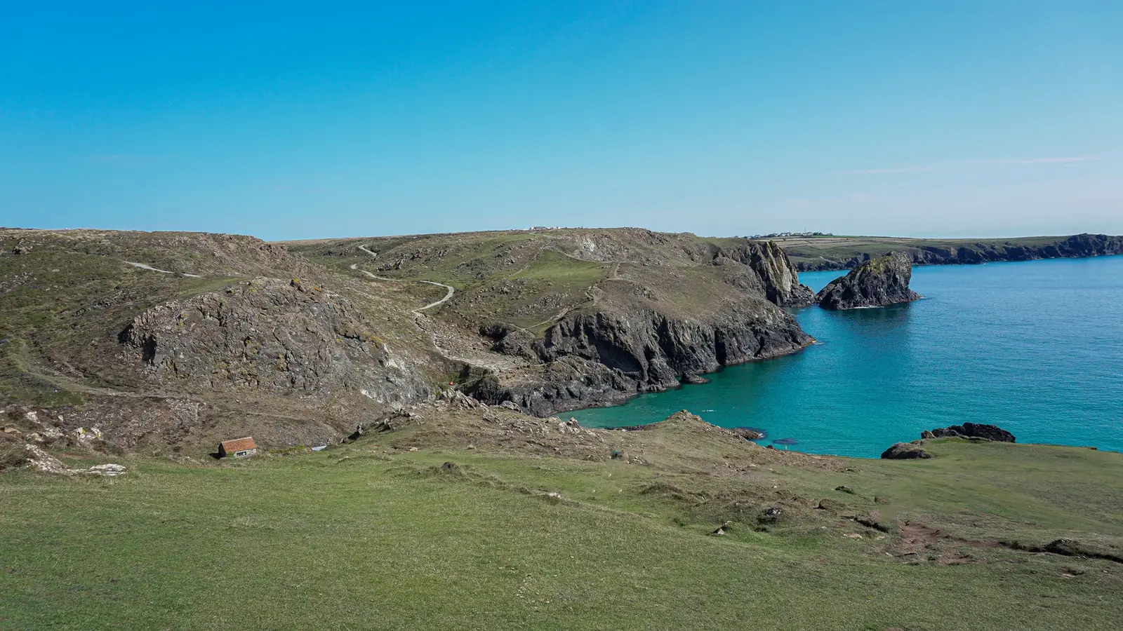Explore the breathtaking cliffs and turquoise waters of Kynance Cove, a top UK tourist spot.