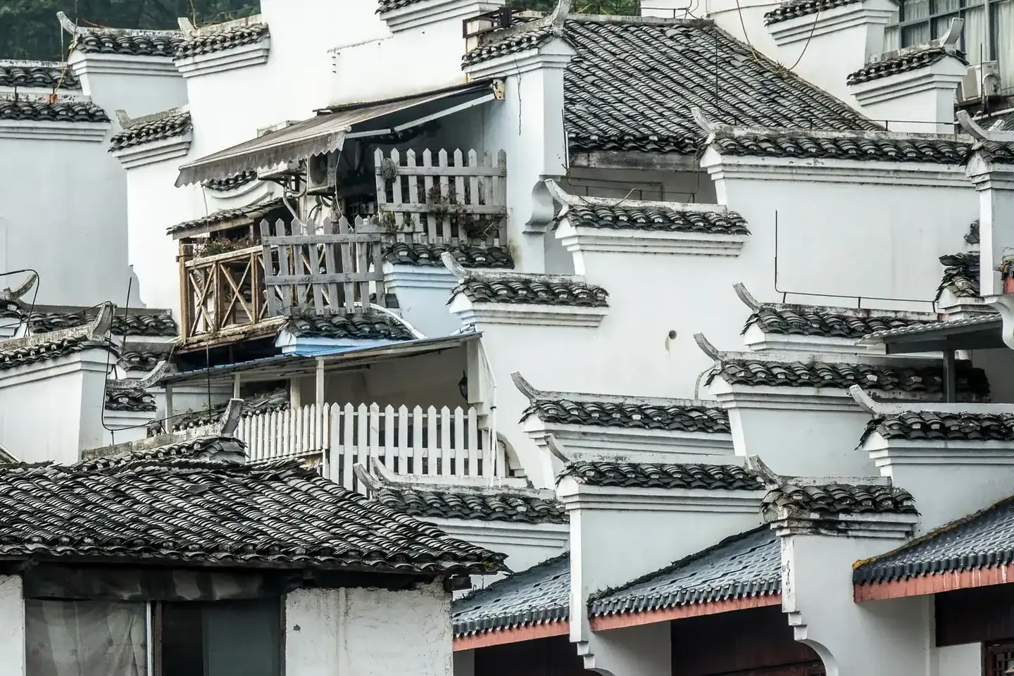 Close-up of traditional white Chinese buildings with intricate tile roofs and balconies.